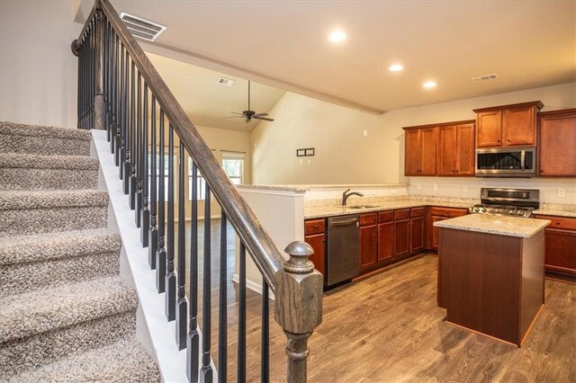610 Sunflower Dr, Canton, GA 30114 - kitchen featuring stainless steel appliances, a sink, wood finished floors, a ceiling fan, and light stone counters