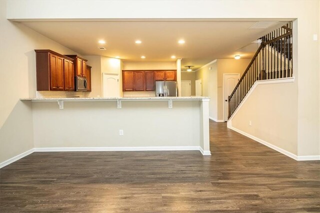 610 Sunflower Dr, Canton, GA 30114 - kitchen featuring stainless steel appliances, dark wood-style flooring, a breakfast bar, a peninsula, and recessed lighting