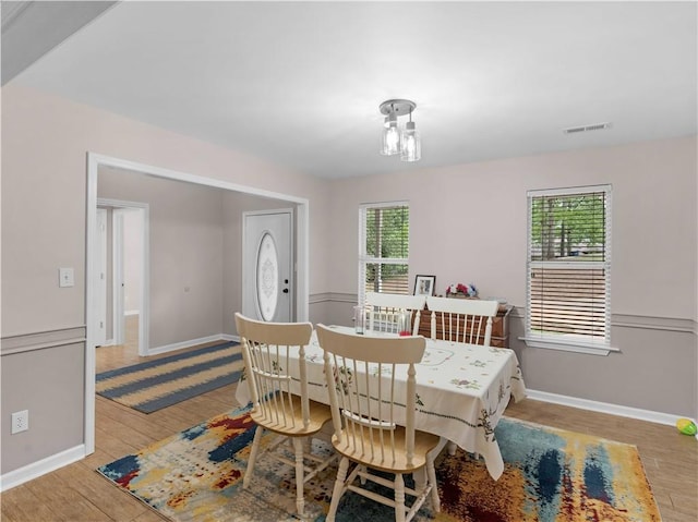 dining area featuring baseboards, visible vents, and wood finished floors