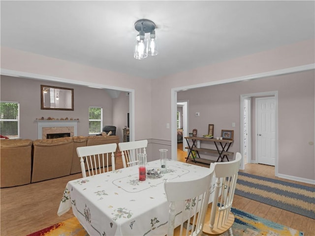 dining space with a fireplace and light wood-style flooring