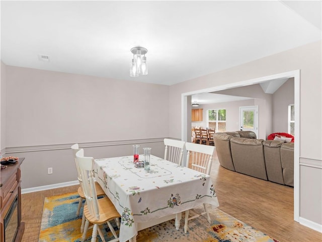 dining space with baseboards, wood finished floors, and visible vents