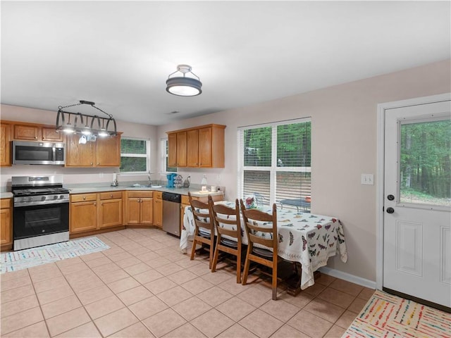 kitchen featuring a sink, light countertops, light tile patterned floors, and stainless steel appliances