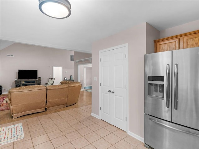 kitchen featuring stainless steel refrigerator with ice dispenser, open floor plan, light tile patterned floors, and visible vents