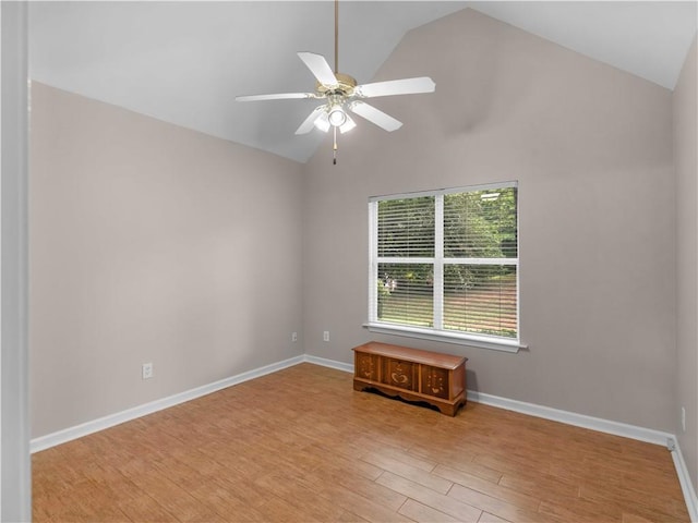 unfurnished room with baseboards, a ceiling fan, vaulted ceiling, and light wood-type flooring