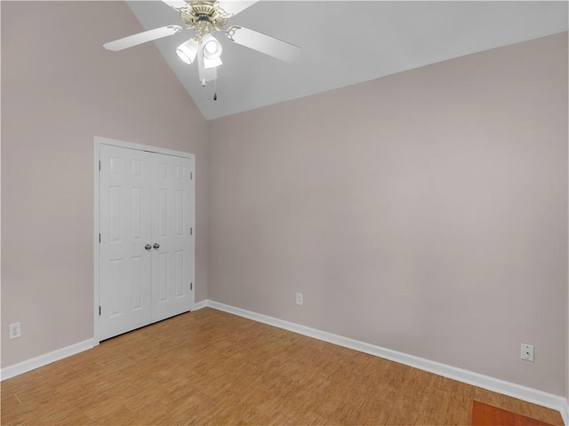 spare room with ceiling fan, vaulted ceiling, baseboards, and light wood finished floors