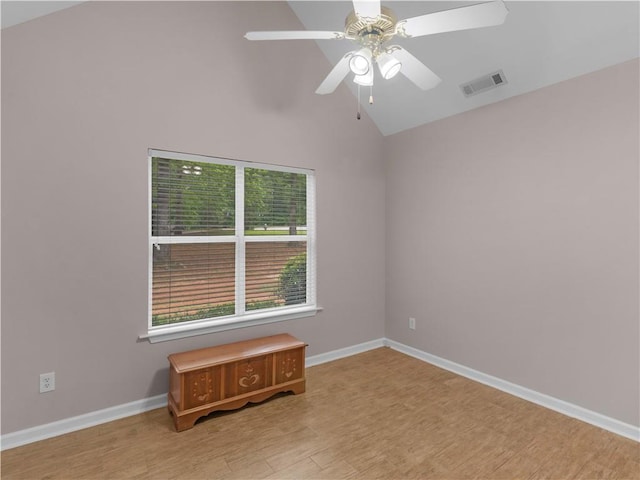 spare room featuring visible vents, wood finished floors, baseboards, high vaulted ceiling, and a ceiling fan