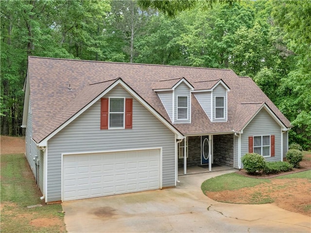 traditional-style home with a porch, roof with shingles, stone siding, and concrete driveway