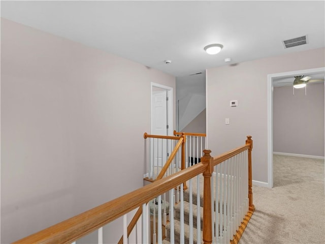 hall featuring carpet flooring, baseboards, an upstairs landing, and visible vents