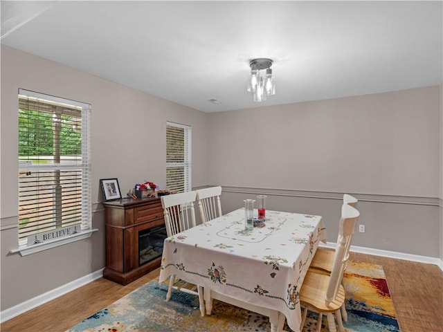 dining space with baseboards and wood finished floors