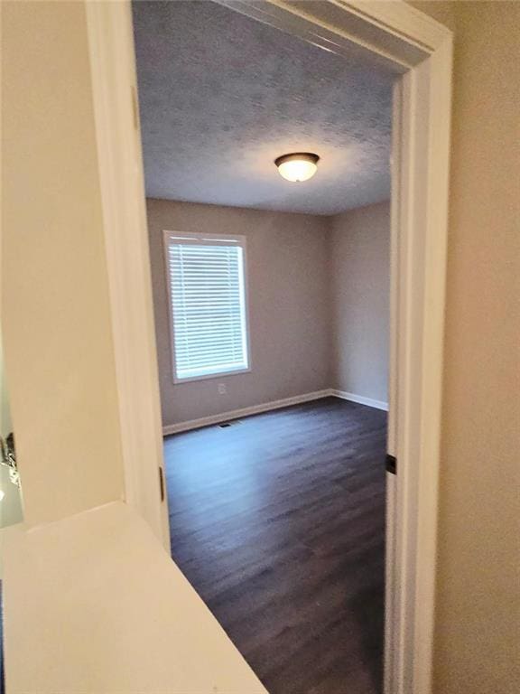204 Twin Pines Ct, Dallas, GA 30132 - spare room featuring dark wood finished floors, baseboards, and a textured ceiling