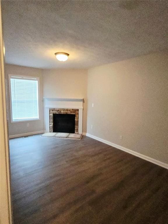 204 Twin Pines Ct, Dallas, GA 30132 - unfurnished living room with baseboards, a textured ceiling, a fireplace, and dark wood finished floors