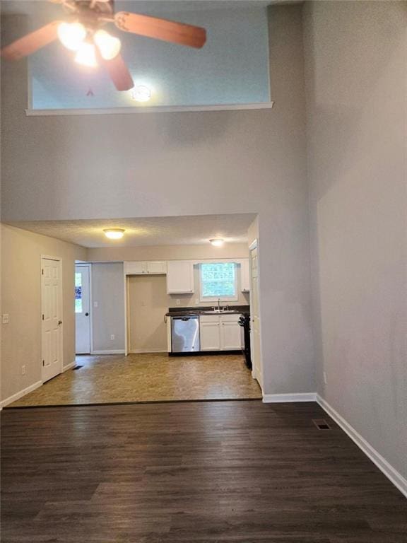 204 Twin Pines Ct, Dallas, GA 30132 - unfurnished living room featuring a sink, a ceiling fan, dark wood finished floors, baseboards, and a towering ceiling