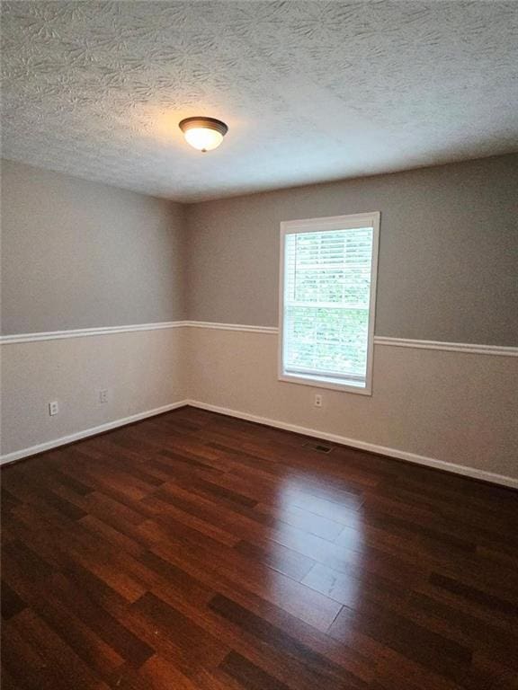 204 Twin Pines Ct, Dallas, GA 30132 - spare room with wood finished floors, a textured ceiling, and baseboards