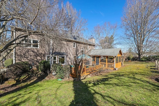 rear view of house with a yard and a sunroom