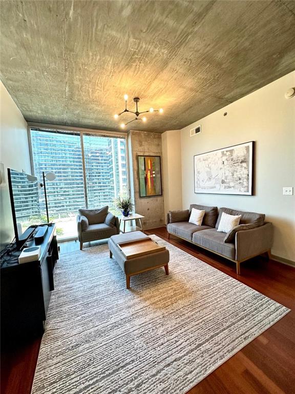855 Peachtree St NE Unit 1406, Atlanta, GA 30308 - living area with wood finished floors, a chandelier, and floor to ceiling windows