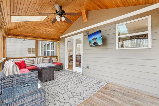 exterior space with wooden ceiling, wood walls, a ceiling fan, and an outdoor living space
