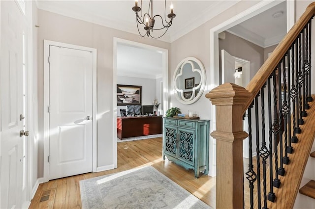 entrance foyer featuring wood finished floors, ornamental molding, visible vents, stairway, and a notable chandelier