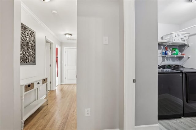 hall with crown molding, washer and clothes dryer, light wood-style flooring, and baseboards
