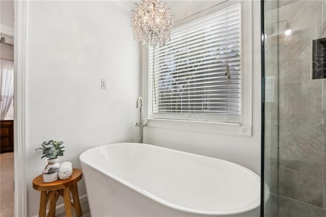 full bathroom featuring a freestanding tub and a notable chandelier