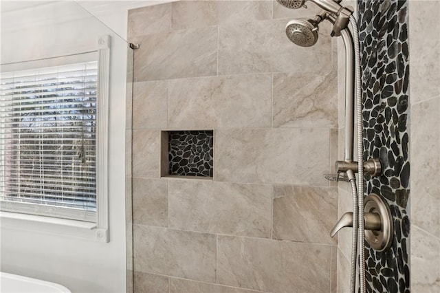 bathroom with tiled shower and a healthy amount of sunlight