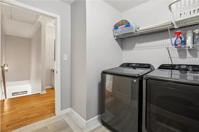 laundry area with independent washer and dryer, laundry area, attic access, light wood-type flooring, and baseboards