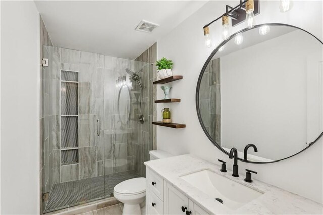 full bathroom with vanity, toilet, a shower stall, and visible vents