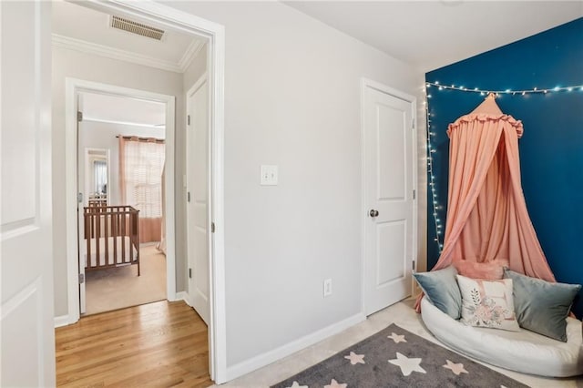 sitting room with ornamental molding, baseboards, visible vents, and wood finished floors