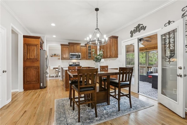 dining area featuring recessed lighting, light wood finished floors, an inviting chandelier, and crown molding