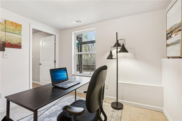 tiled office space with baseboards and visible vents
