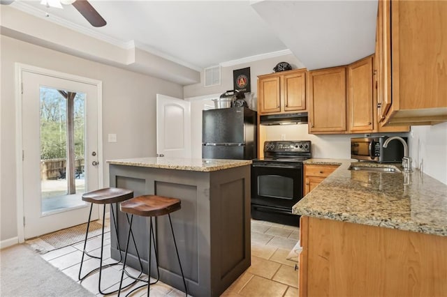 kitchen with black appliances, a sink, crown molding, and under cabinet range hood