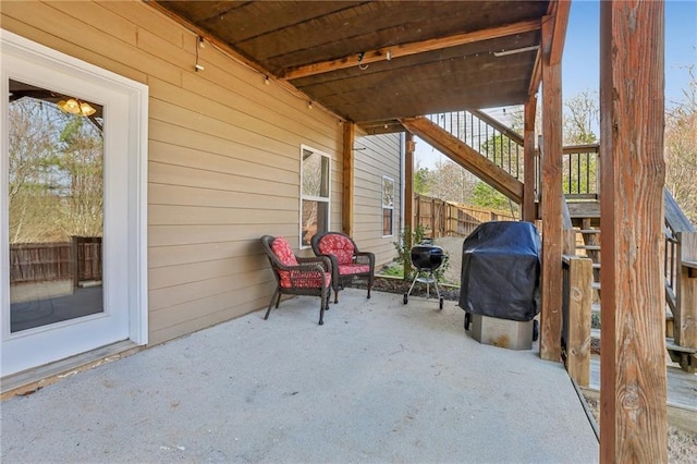 view of patio with stairway, area for grilling, and fence