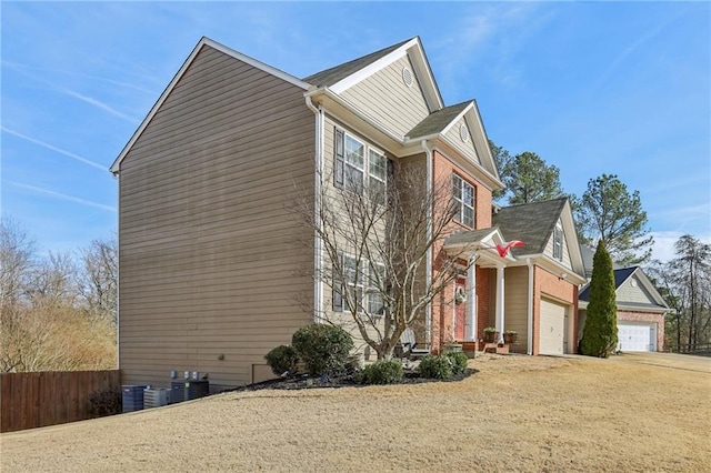 view of side of home featuring central air condition unit, driveway, and fence