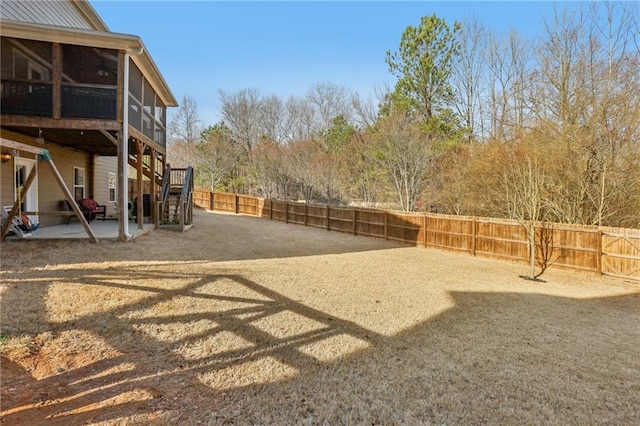 view of yard featuring stairway, a patio, a sunroom, and a fenced backyard