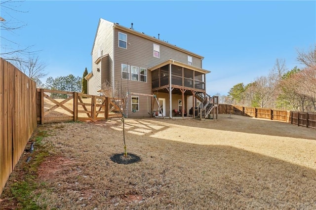 back of property featuring stairway, a sunroom, and a fenced backyard