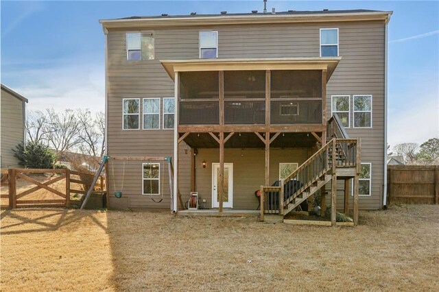 rear view of house featuring stairway, a sunroom, a fenced backyard, and a patio area
