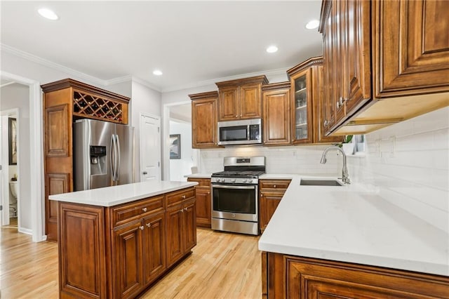 kitchen featuring light countertops, light wood-style floors, stainless steel appliances, and a sink