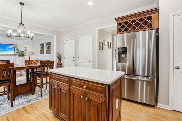 kitchen featuring stainless steel fridge, a chandelier, light wood-style flooring, and decorative light fixtures