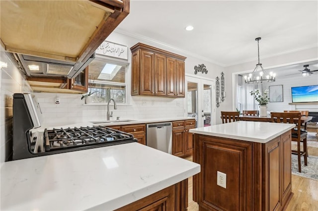 kitchen featuring a sink, gas range, a healthy amount of sunlight, and dishwasher