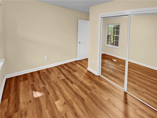 unfurnished bedroom with a closet and wood-type flooring