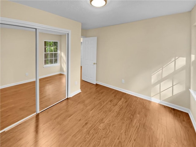 unfurnished bedroom featuring a closet and wood-type flooring