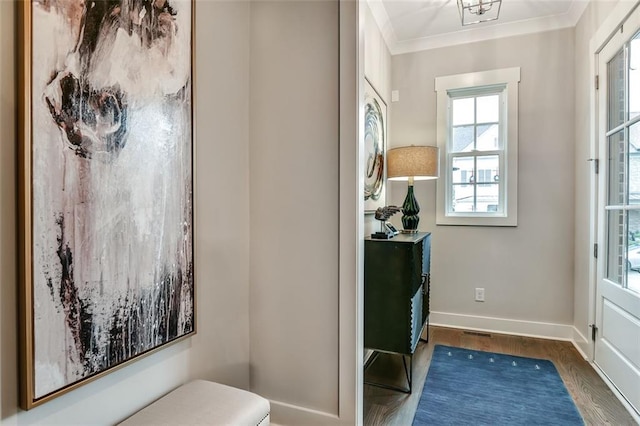 interior space featuring crown molding, baseboards, and wood finished floors