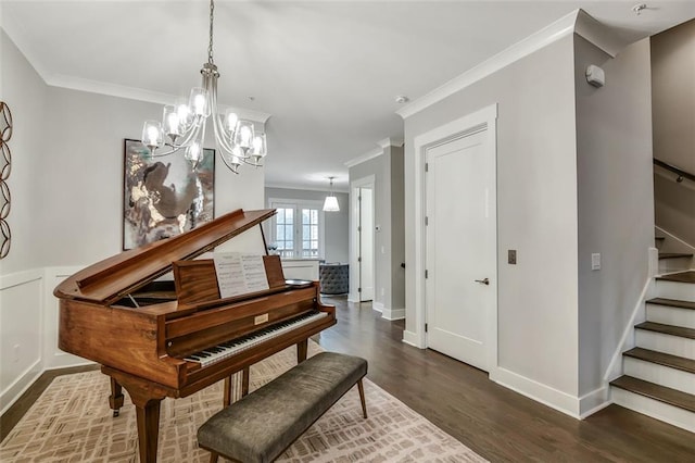 sitting room featuring stairs, a notable chandelier, crown molding, and dark wood-style floors