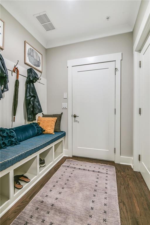 mudroom with baseboards, visible vents, and wood finished floors
