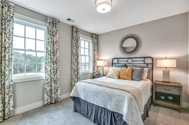 carpeted bedroom featuring baseboards and visible vents