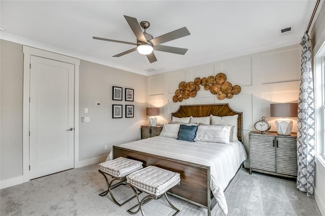 bedroom with carpet floors, ornamental molding, ceiling fan, and visible vents