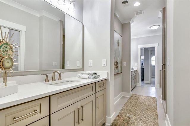 bathroom with baseboards, visible vents, ornamental molding, and vanity