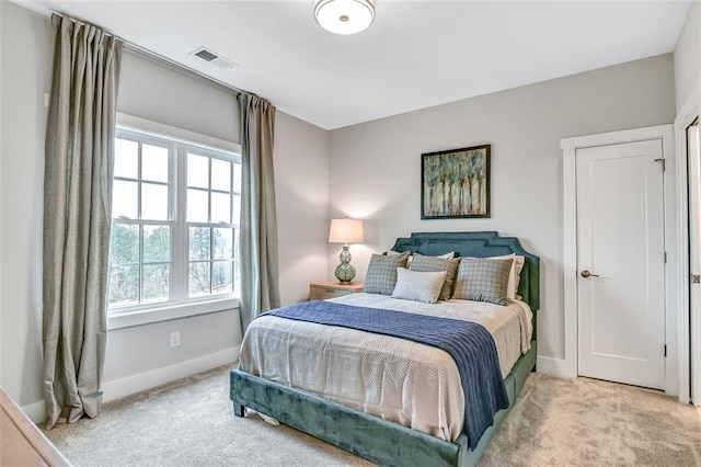 carpeted bedroom featuring baseboards and visible vents