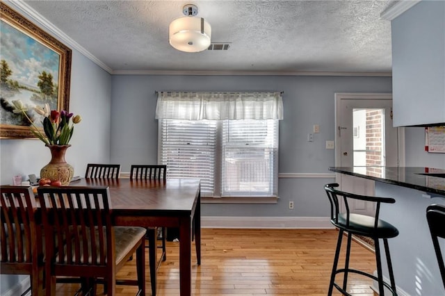 6118 Queen Anne Ct, Norcross, GA 30093 - dining space featuring light wood finished floors, ornamental molding, baseboards, and a textured ceiling