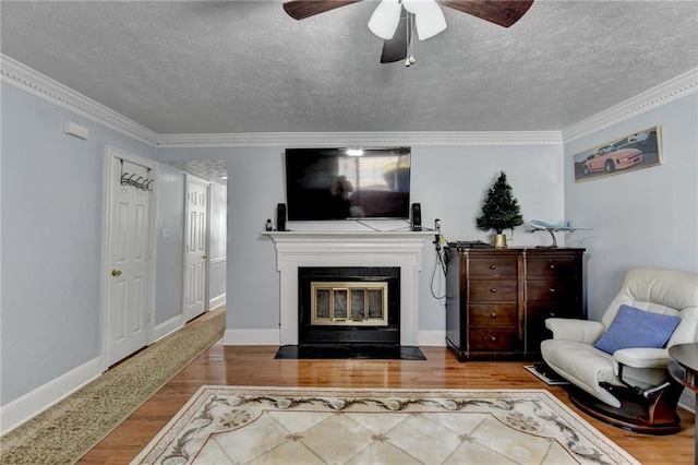 6118 Queen Anne Ct, Norcross, GA 30093 - living room with a textured ceiling, wood finished floors, a ceiling fan, a fireplace with flush hearth, and ornamental molding