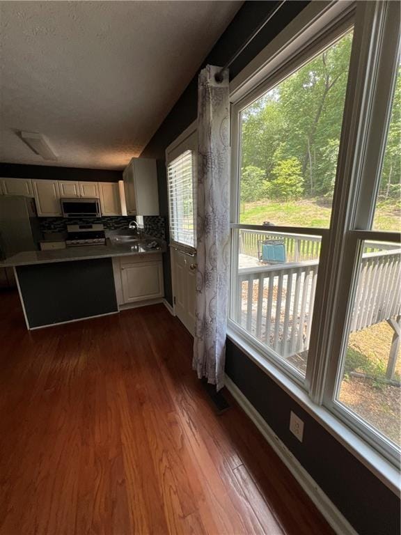 11 Seabreeze Way, Dawsonville, GA 30534 - kitchen featuring appliances with stainless steel finishes, dark wood finished floors, a peninsula, and cream cabinetry